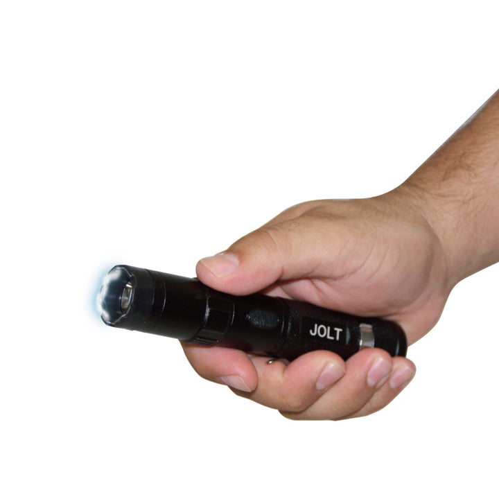 JOLT stun flashlight in hand with bright LED light activated for self defense use