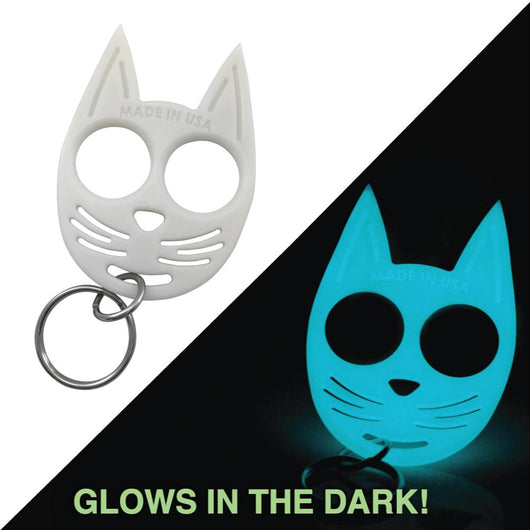 White glow-in-the-dark cat self-defense keychain shown glowing at night