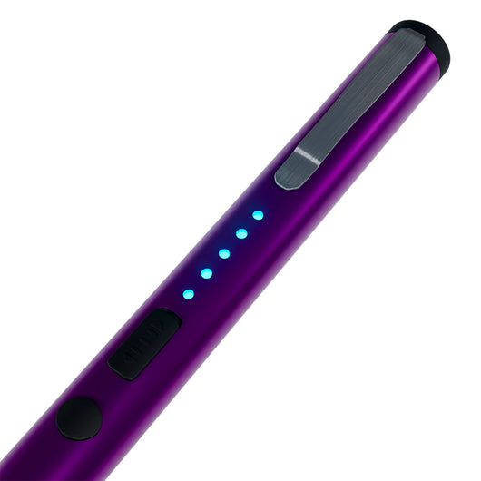 Close-up of purple pen stun gun showing LED battery indicator lights and safety switch