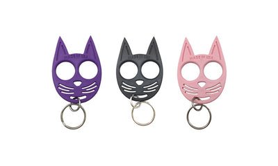 Cat-shaped self-defense keychains in purple, black, and light pink, made in USA.
